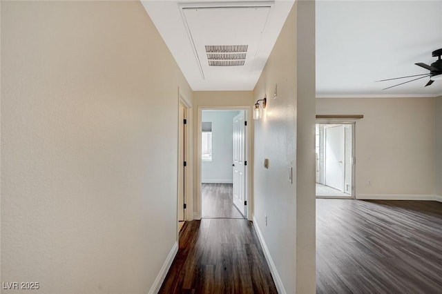 corridor featuring visible vents, baseboards, and dark wood-style flooring