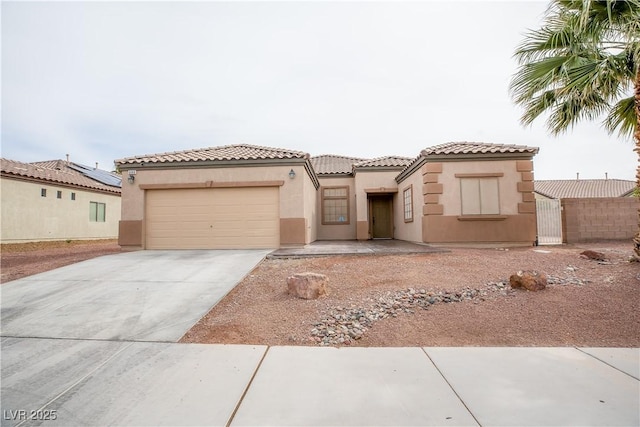 mediterranean / spanish-style home with a tiled roof, a garage, driveway, and stucco siding