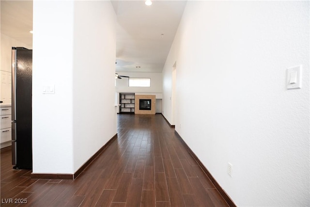 corridor featuring dark wood-style floors and baseboards