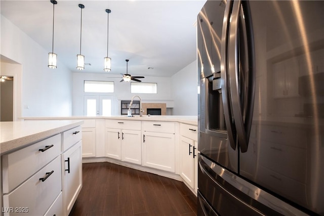 kitchen with ceiling fan, light stone countertops, dark wood finished floors, stainless steel refrigerator with ice dispenser, and white cabinets