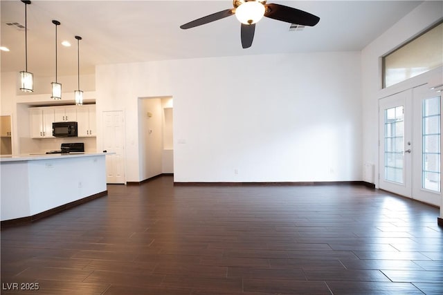 unfurnished living room with visible vents, baseboards, ceiling fan, and dark wood-style flooring