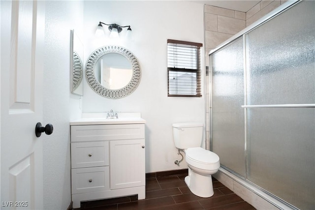 full bath featuring baseboards, wood tiled floor, toilet, a stall shower, and vanity