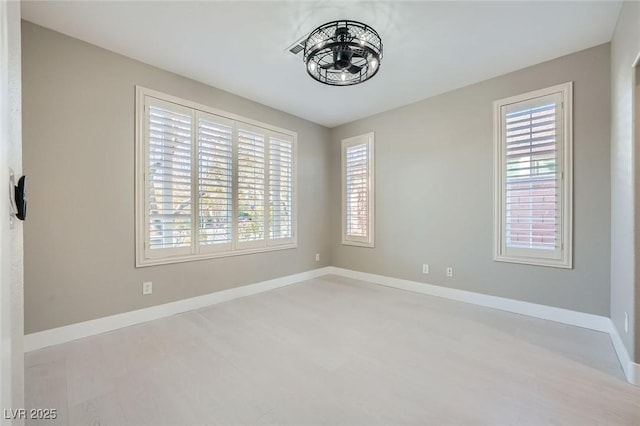 spare room featuring baseboards and a healthy amount of sunlight