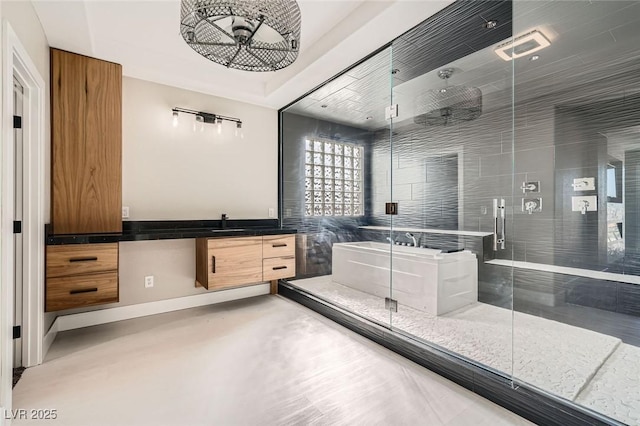 full bath with a shower stall, vanity, baseboards, and a freestanding tub