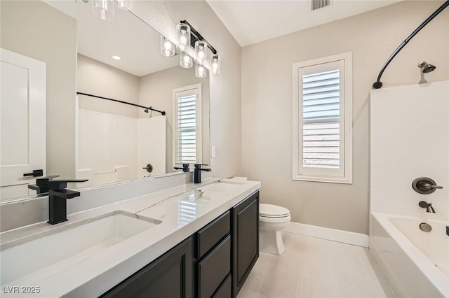 bathroom featuring a sink, plenty of natural light, and toilet