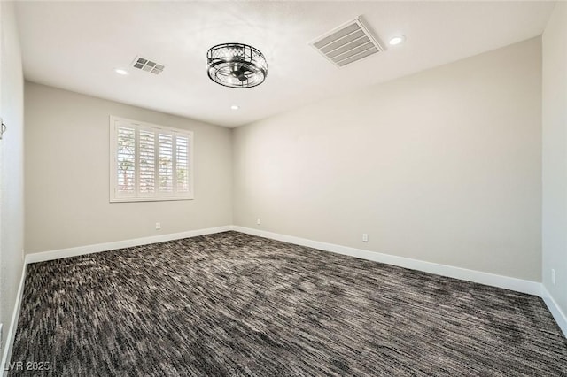 carpeted spare room featuring recessed lighting, baseboards, and visible vents