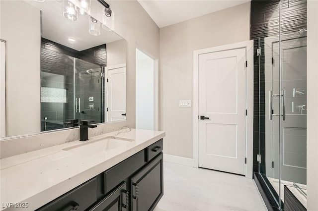 bathroom featuring a stall shower, vanity, and baseboards