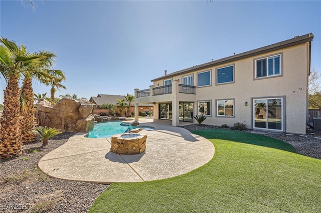 rear view of house featuring a patio, a balcony, a fenced in pool, a yard, and stucco siding