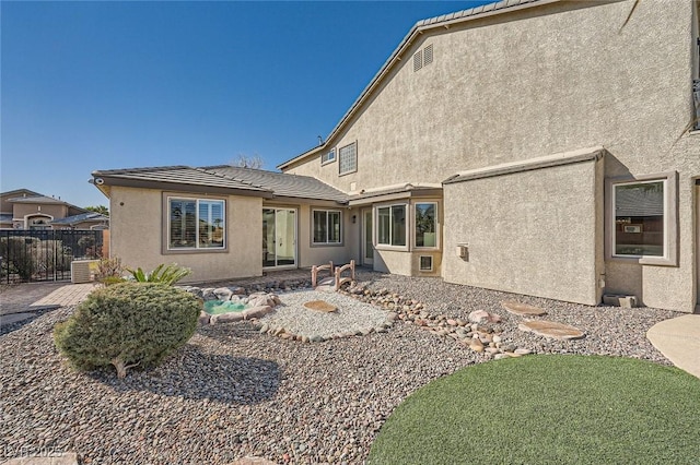 back of house with a patio area, a tiled roof, fence, and stucco siding