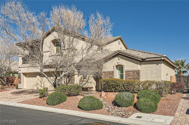 view of front of house with a tiled roof, stucco siding, a garage, stone siding, and driveway