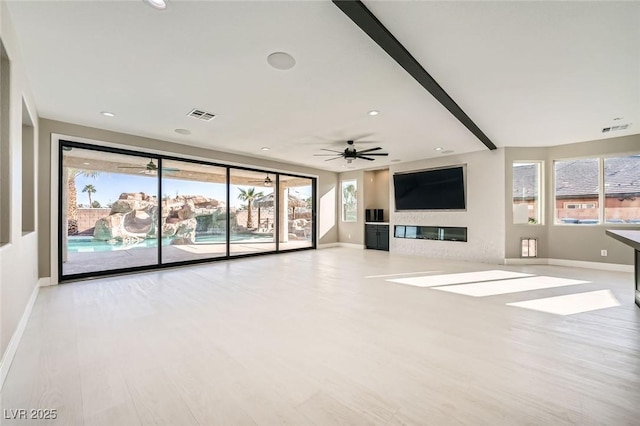 unfurnished living room with visible vents, wood finished floors, baseboards, and ceiling fan