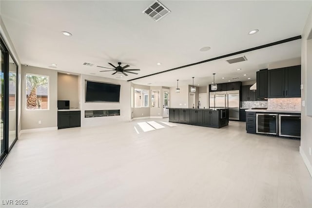 unfurnished living room with recessed lighting, visible vents, wine cooler, and ceiling fan