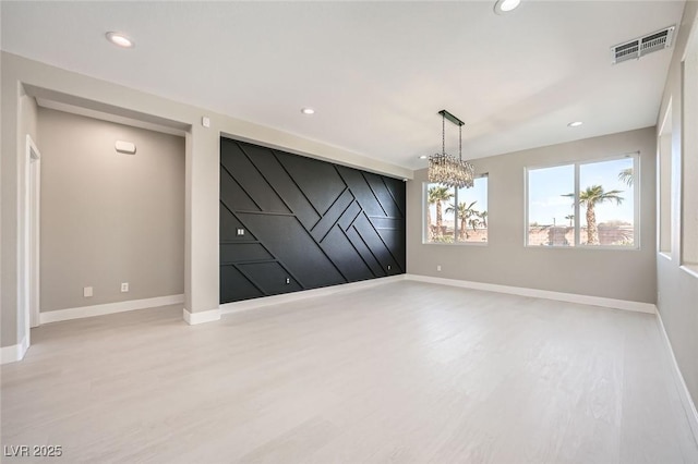 empty room featuring recessed lighting, visible vents, baseboards, and wood finished floors