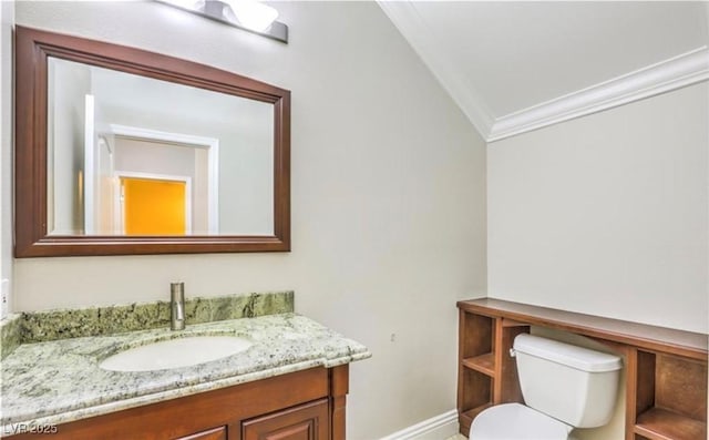 half bath with baseboards, toilet, lofted ceiling, ornamental molding, and vanity