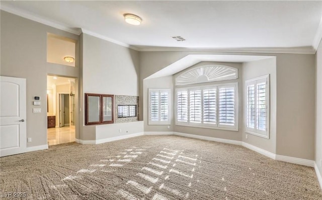 carpeted empty room with visible vents, lofted ceiling, crown molding, and baseboards