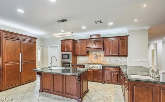 kitchen with a sink, visible vents, built in appliances, and a peninsula