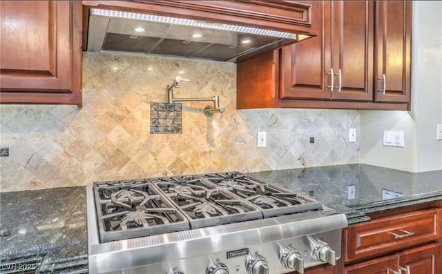 kitchen with decorative backsplash, custom exhaust hood, stove, and dark stone counters