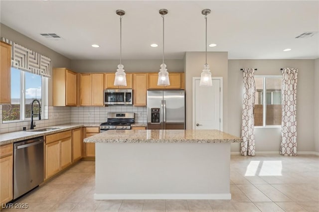 kitchen featuring tasteful backsplash, visible vents, stainless steel appliances, and a sink