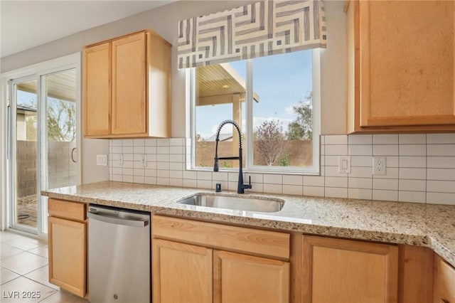 kitchen featuring backsplash, light brown cabinetry, a sink, dishwasher, and a wealth of natural light