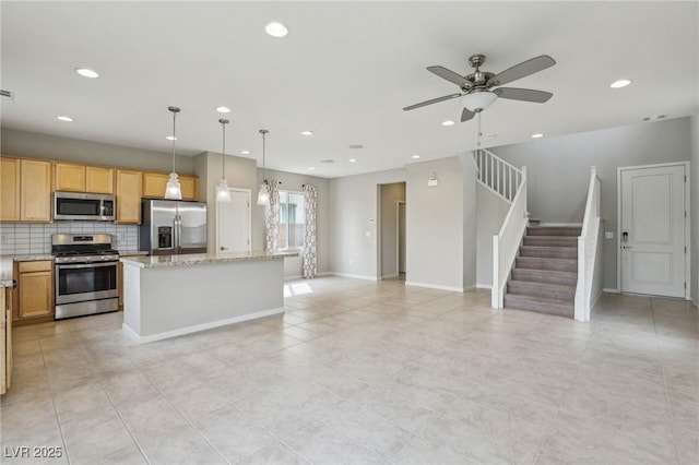 kitchen featuring a center island, recessed lighting, appliances with stainless steel finishes, decorative backsplash, and ceiling fan