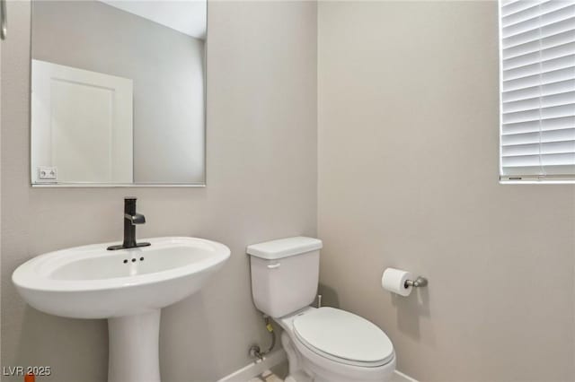 half bath with toilet and baseboards