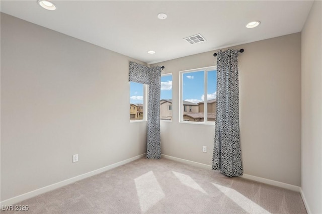 unfurnished room with visible vents, recessed lighting, baseboards, and light carpet