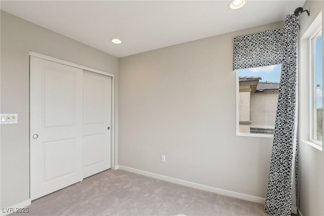 unfurnished bedroom featuring recessed lighting, a closet, baseboards, and carpet flooring