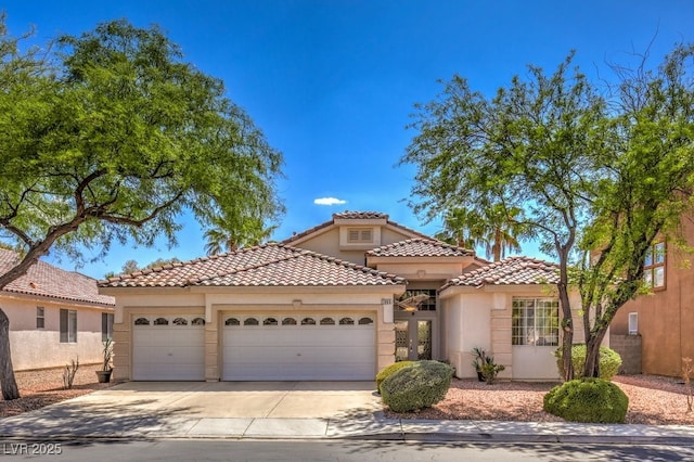 mediterranean / spanish-style home featuring a garage, concrete driveway, stucco siding, and a tile roof