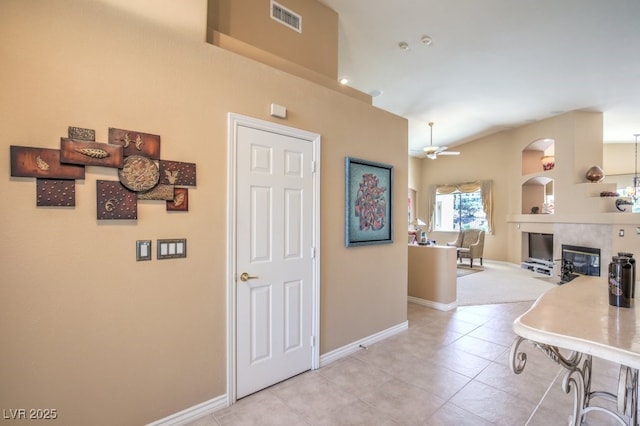 interior space featuring light tile patterned floors, arched walkways, visible vents, and baseboards