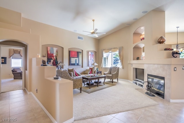 living area featuring light carpet, visible vents, a ceiling fan, and light tile patterned floors