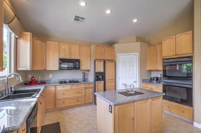 kitchen with black appliances, vaulted ceiling, light brown cabinets, and a sink