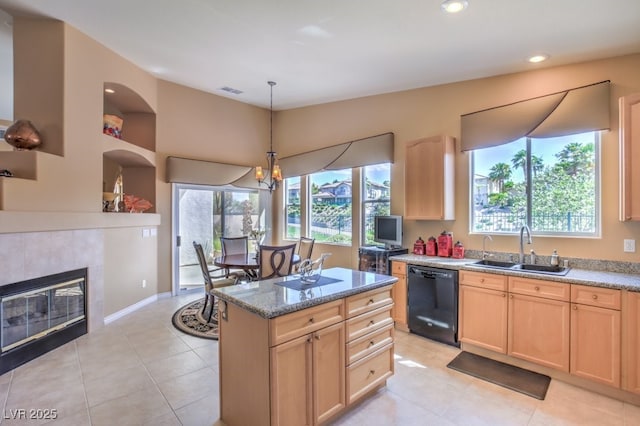 kitchen featuring black dishwasher, light brown cabinets, a wealth of natural light, and a sink