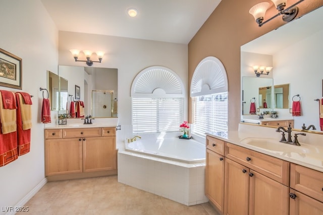 bathroom featuring tile patterned floors, a bath, a stall shower, and a sink