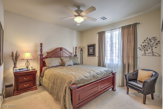 bedroom with a ceiling fan, visible vents, and light carpet