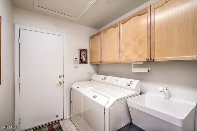 laundry area with cabinet space, separate washer and dryer, and a sink