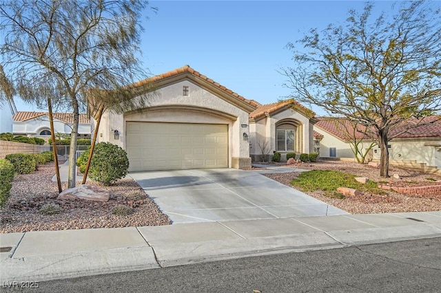 mediterranean / spanish-style home featuring stucco siding, driveway, a tile roof, and a garage