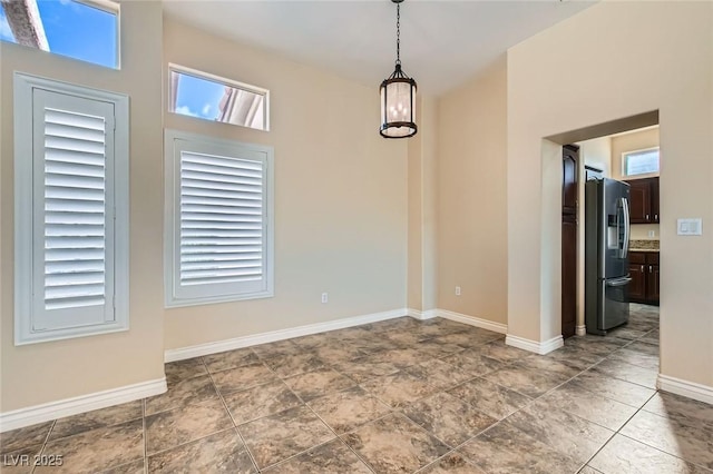 unfurnished dining area with baseboards