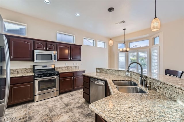 kitchen featuring dark brown cabinets, recessed lighting, appliances with stainless steel finishes, hanging light fixtures, and a sink