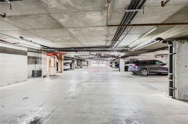 garage with central air condition unit and concrete block wall