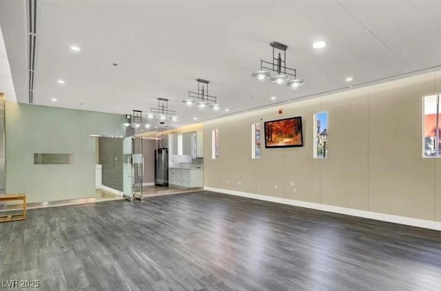 unfurnished living room with baseboards and wood finished floors