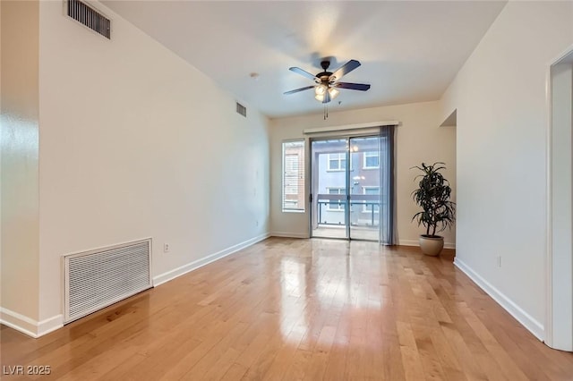 empty room featuring visible vents, baseboards, ceiling fan, and light wood finished floors