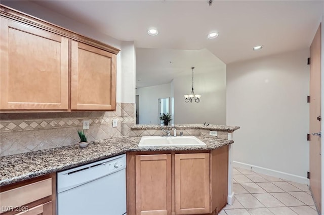 kitchen featuring light brown cabinets, a peninsula, a sink, dishwasher, and tasteful backsplash