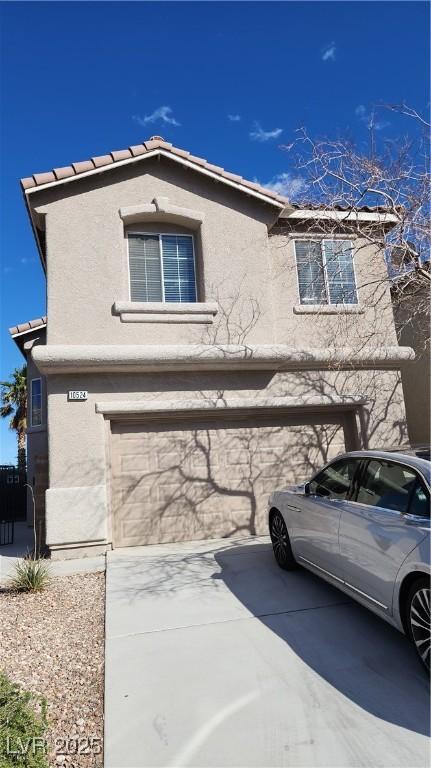 view of side of home with a garage, driveway, and stucco siding