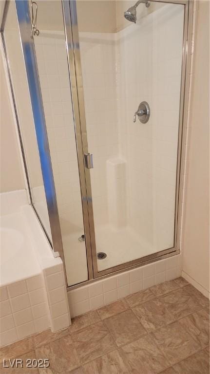 bathroom featuring a shower stall and a garden tub