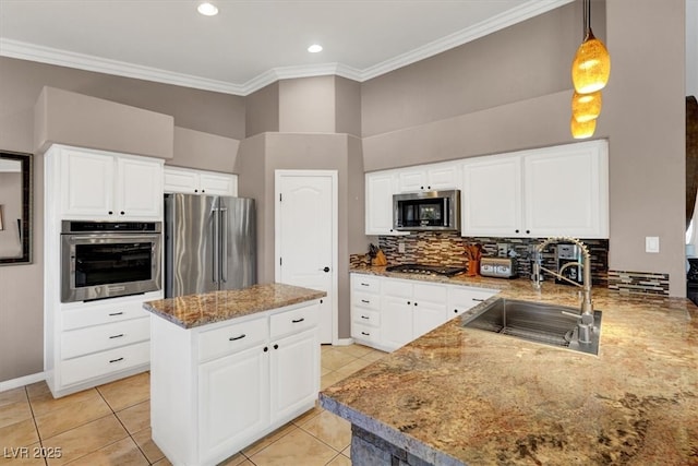 kitchen featuring tasteful backsplash, ornamental molding, light stone counters, appliances with stainless steel finishes, and a sink