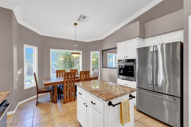 kitchen with stainless steel appliances, visible vents, light tile patterned flooring, and crown molding