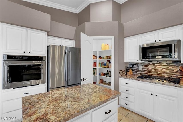 kitchen with tasteful backsplash, stainless steel appliances, white cabinets, crown molding, and light stone countertops