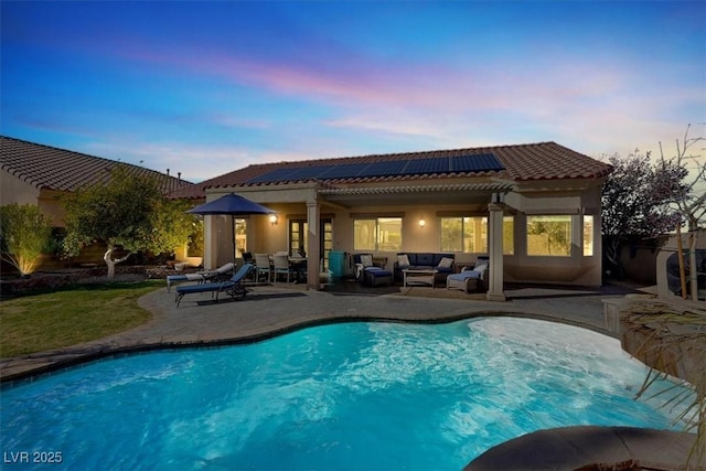 pool with an outdoor living space and a patio