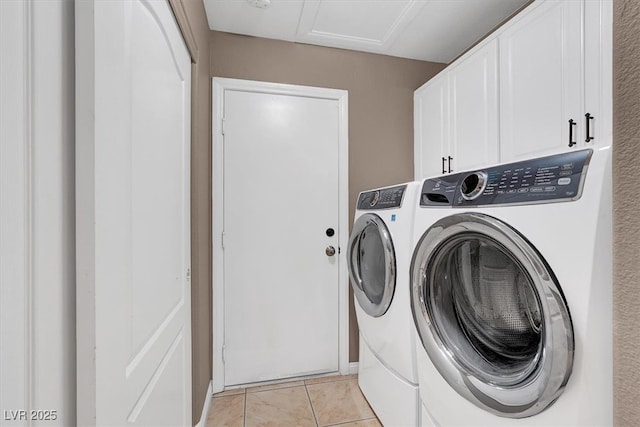 clothes washing area with light tile patterned floors, cabinet space, and separate washer and dryer