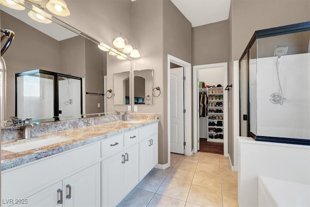 bathroom with tile patterned flooring, a stall shower, and a sink